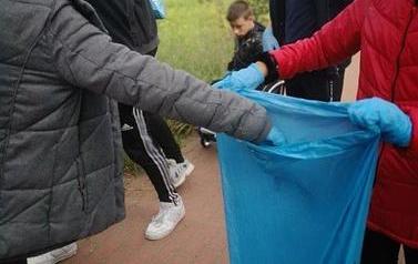 Dzieci wrzucające śmieci do worka