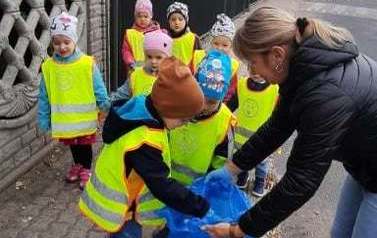 Dzieciaki z przedszkola Łubnicy podczas sprzątania. Pani kt&oacute;ra pomaga