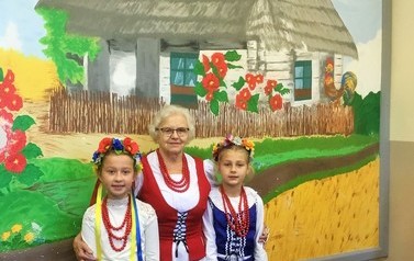 Pani Zofia Cugier wraz z dwoma dziewczynkami w strojach ludowych