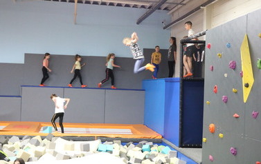Zdjęcie przedstawia grupę dzieci na trampolinach 