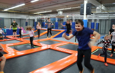Zdjęcie przedstawia grupę dzieci na trampolinach 